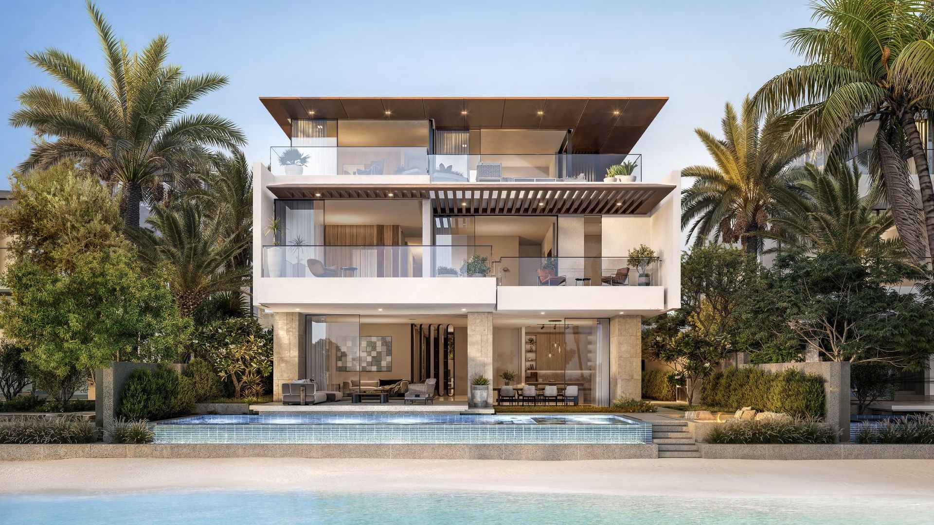 Modern beachfront villa with balconies and swimming pool, surrounded by lush palm trees.